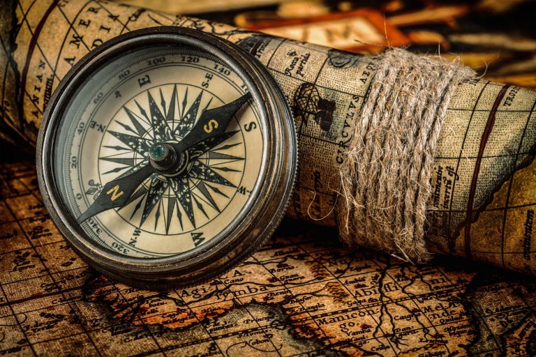 Old vintage compass on ancient map