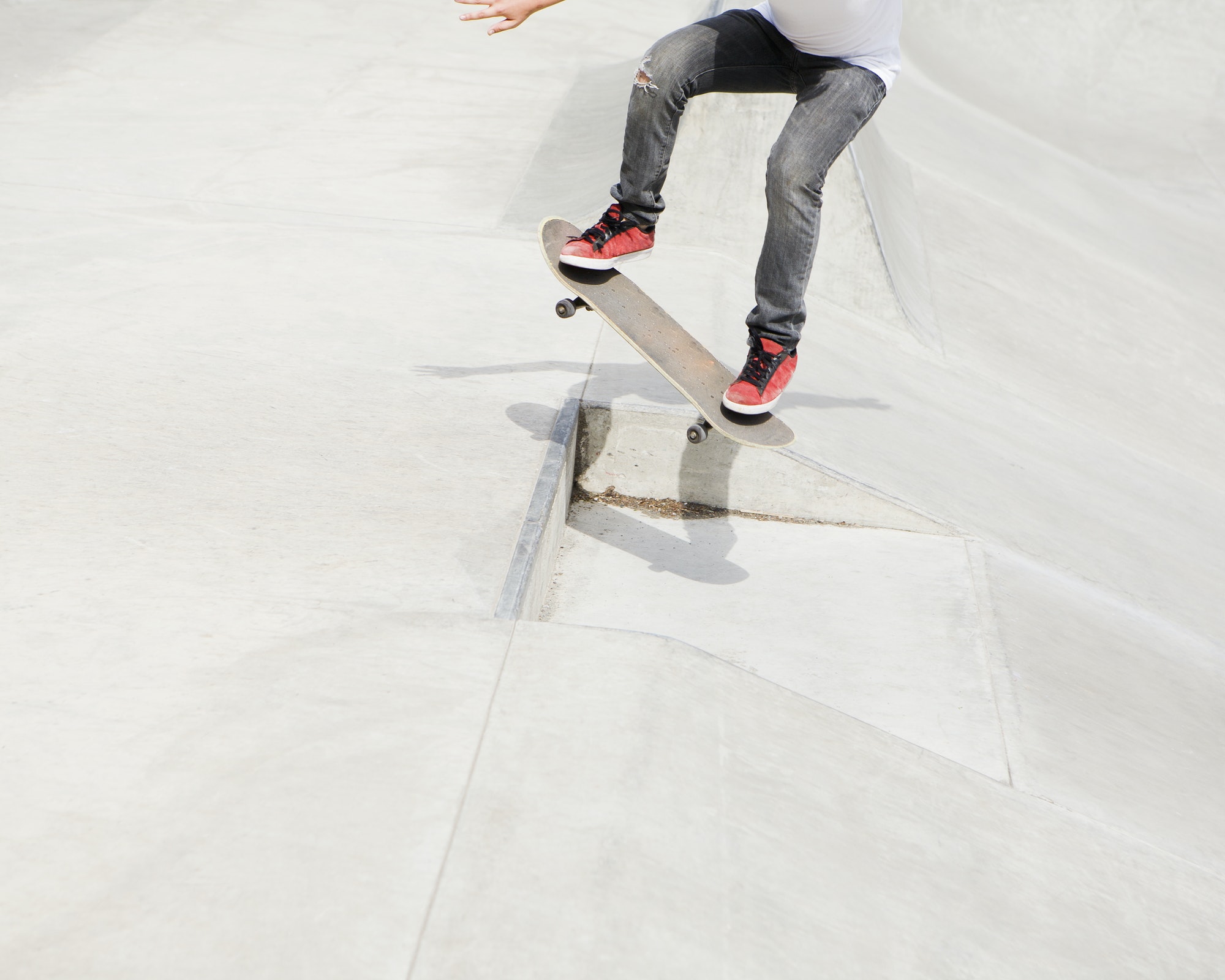 A teenage boy balancing on a skateboard in the city.