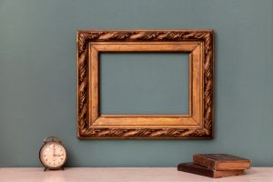 Empty gold vintage picture frame with books