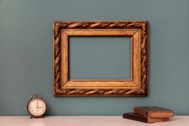 Empty gold vintage picture frame with books