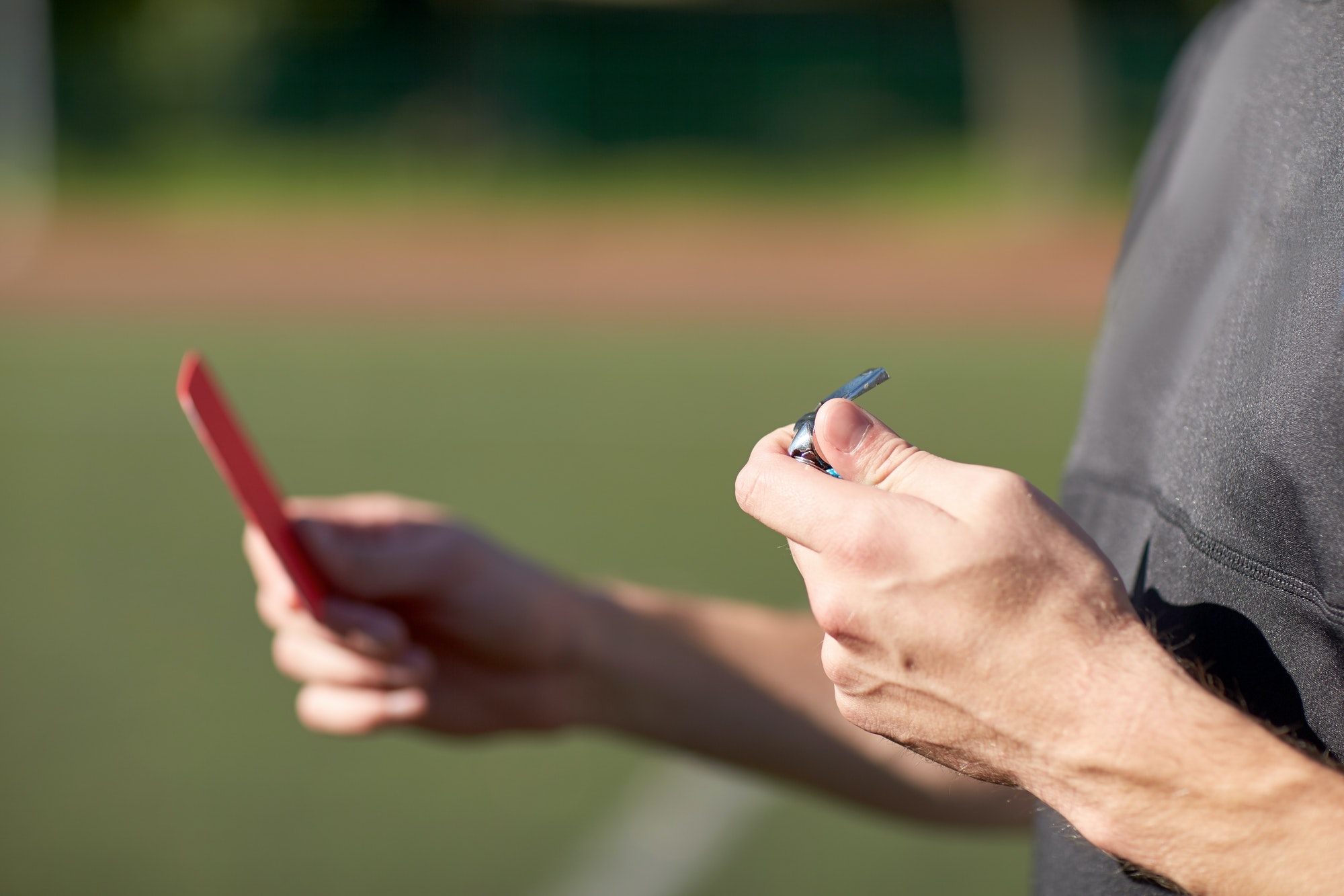 referee hands with red card on football field